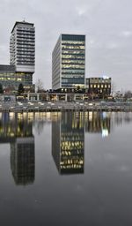 Reflection of buildings in lake against sky