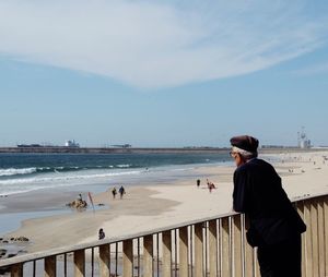 Woman standing on beach against clear sky