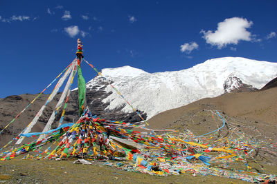 Colorful prayer flags in front of snow-capped mountains against sky