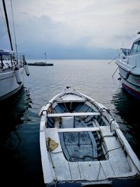 Sailboats moored on sea against sky