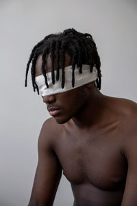 Portrait of young man wearing hat against white background