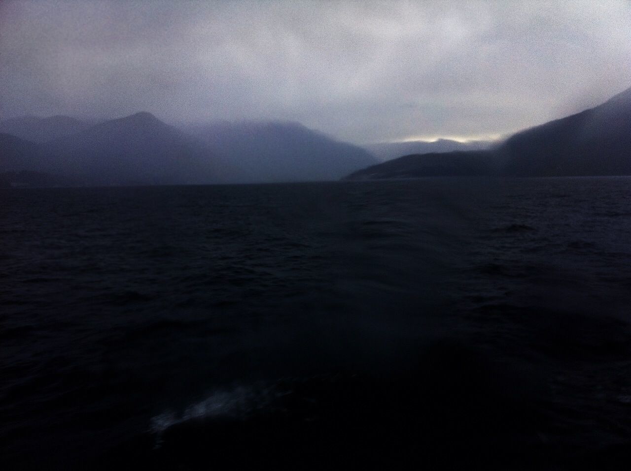 SCENIC VIEW OF SEA WITH MOUNTAIN IN BACKGROUND