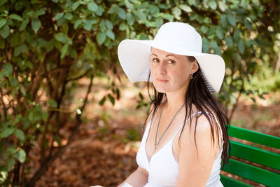 Happy cute brunette woman in park on summer day. cheerful beautiful woman