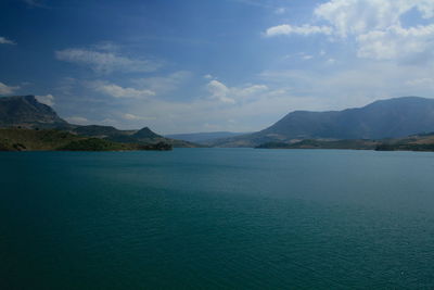 Scenic view of sea and mountains against sky