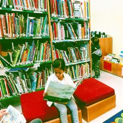 Full length of boy sitting on book