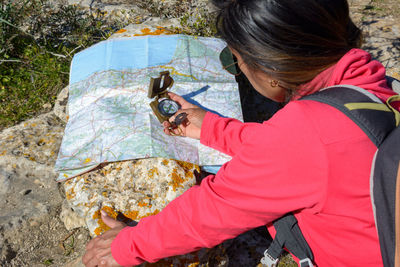 Latin woman hikers looking at map with a compass. trekking