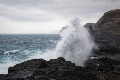 Waves breaking on rocks against sea