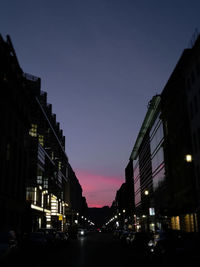 Cars on road in city against clear sky at night