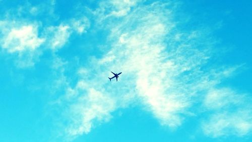 Low angle view of airplane against blue sky