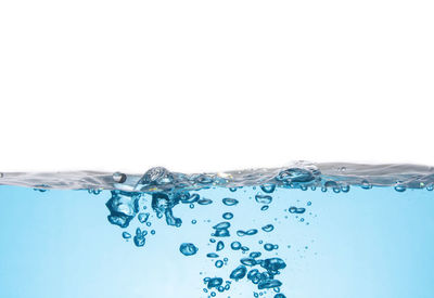 Close-up of water splashing against white background