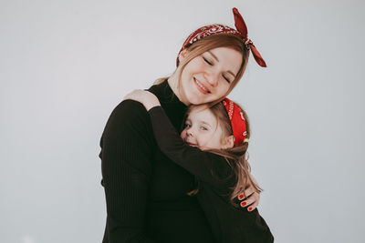 Portrait of young woman with teddy bear against white background