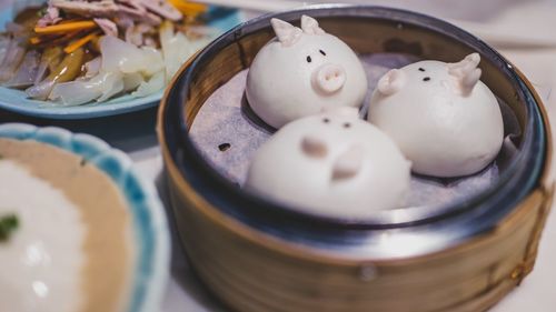Close-up of pig shape dumplings in container on table