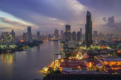 Illuminated buildings in city against sky