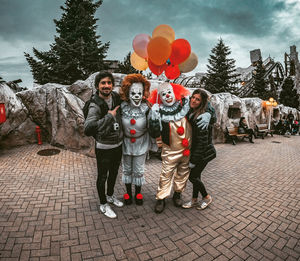 Group of people with balloons against trees