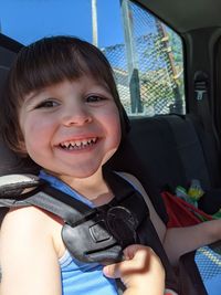 Portrait of cute boy sitting in car