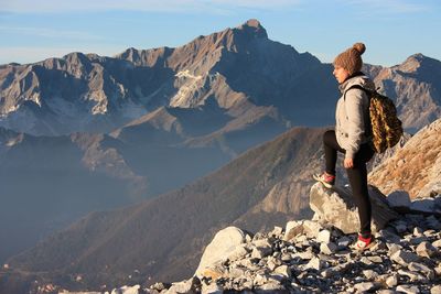 Woman standing on mountain against sky