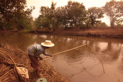 Fisherman fishing from river