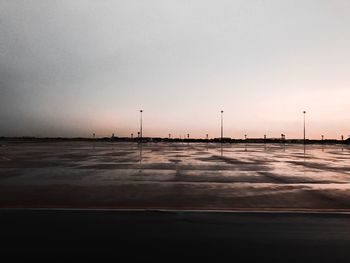 Airplane at airport against sky during sunset