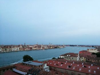 High angle view of townscape by sea against sky