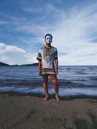 Young man wearing mask while standing at beach