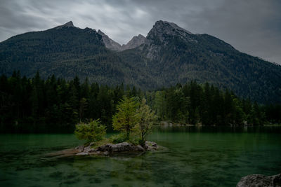 Scenic view of lake by mountains against sky