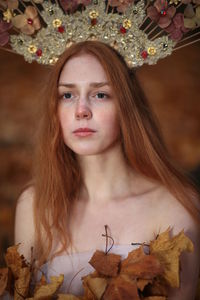 Thoughtful young woman with redhead wearing flowers on hair