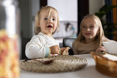 Portrait of cute girl with food at home