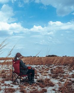 Woman on folding chair on landscape in winter