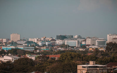 Buildings in city against clear sky
