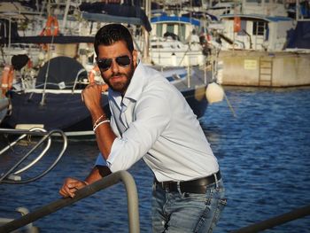 Man wearing sunglasses standing at harbor