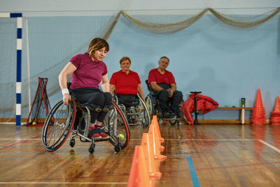 Side view of woman using mobile phone while sitting on wheelchair