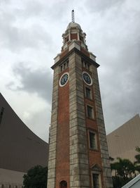 Low angle view of clock tower against cloudy sky