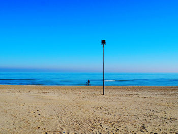 Scenic view of beach against clear blue sky