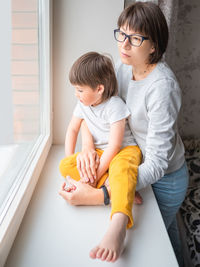 Sad woman looks at window. stay at home because of coronavirus covid-19 quarantine. mother and son.