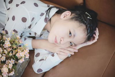 Portrait of cute baby girl on bed at home