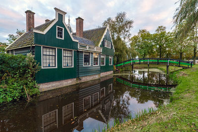 Building by lake against sky