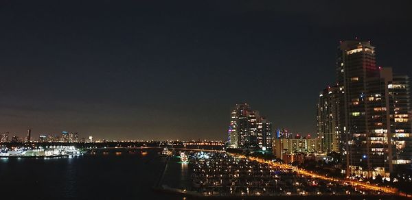 Illuminated buildings in city against sky at night