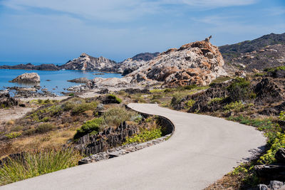 Scenic view of road by mountains against sky