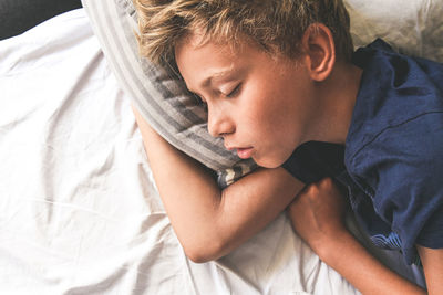 High angle view of boy sleeping on bed