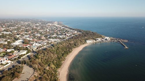 High angle view of townscape by sea against sky