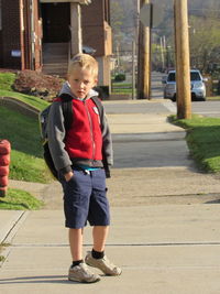 Full length of boy standing on footpath