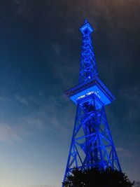 Low angle view of illuminated tower against sky at night