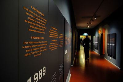 Rear view of man standing by illuminated text on wall