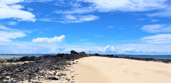 Scenic view of beach against blue sky