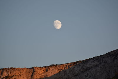 Low angle view of moon against clear sky at night