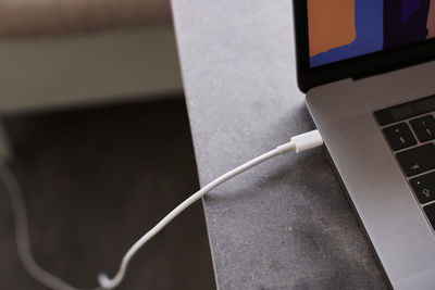 Close-up of laptop with plugged cable