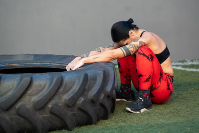 Side view of woman sitting on field