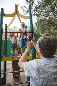 Father taking picture of kids at playground