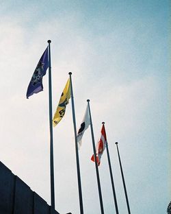 Low angle view of flags against sky