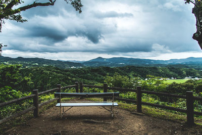 Empty bench overlooking countryside landscape